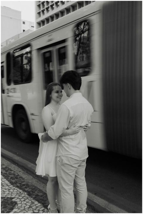 A couple in love embraces on a city street as a bu