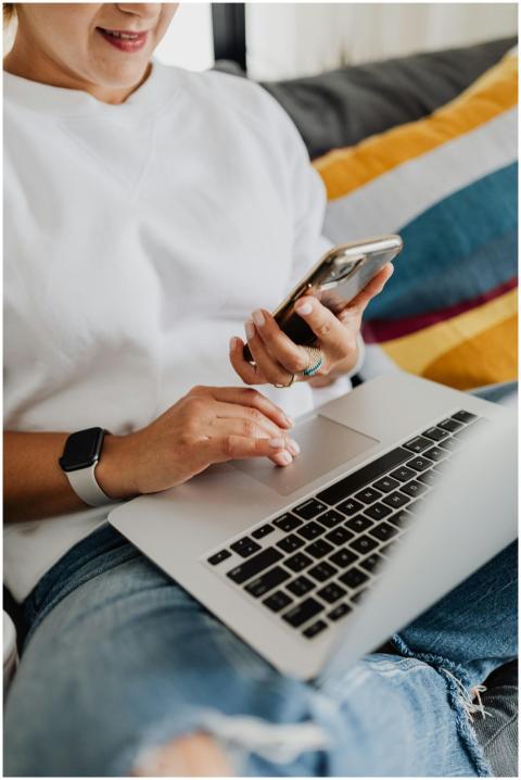 A person multitasking with a laptop and smartphone
