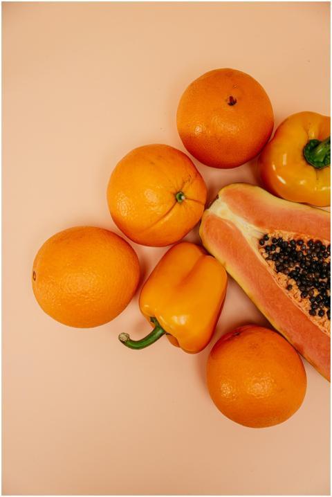 A top-down view of oranges, papaya, and bell peppe