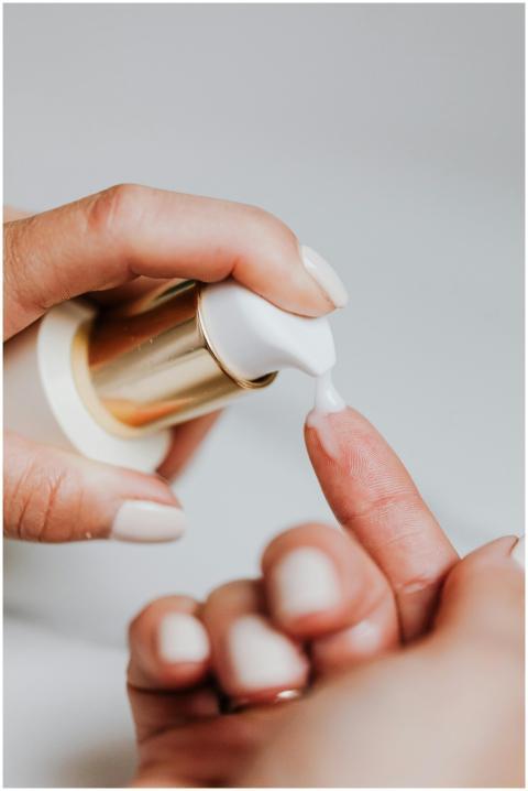 A woman applies skincare lotion from a pump bottle