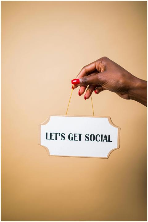 A hand holding a "Let's Get Social" sign, ideal fo