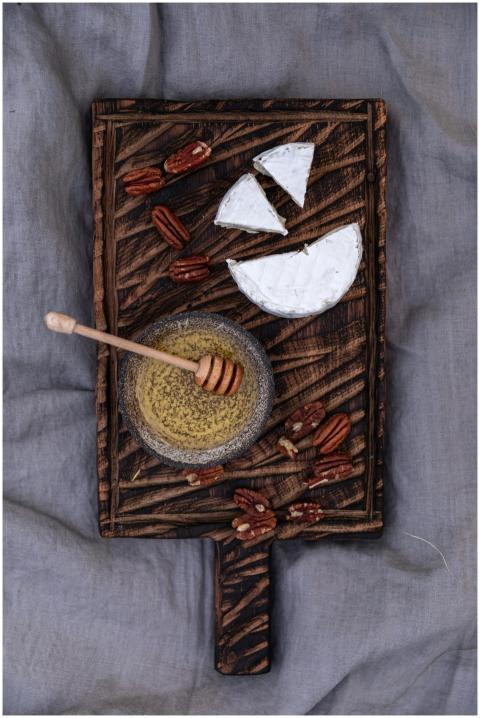 A stylish still life of cheese, honey, and nuts on