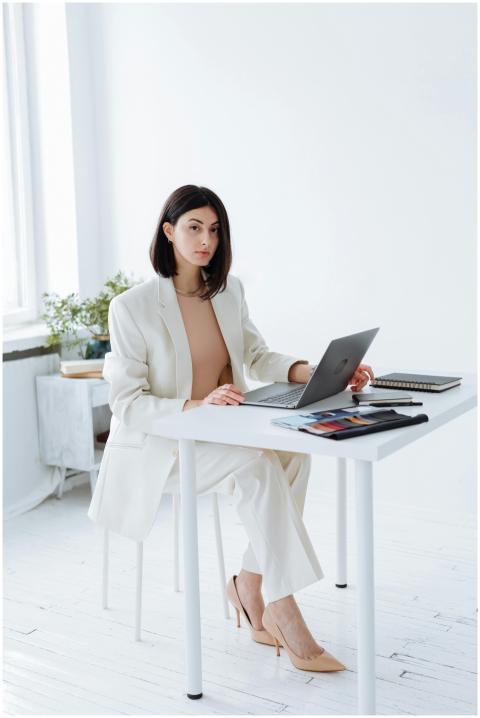 Elegant businesswoman in a white blazer working on