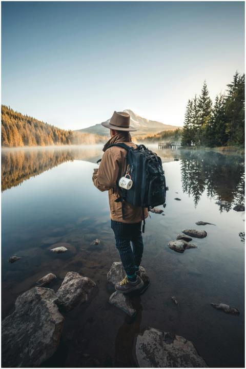 A hiker with a backpack stands by a tranquil mount