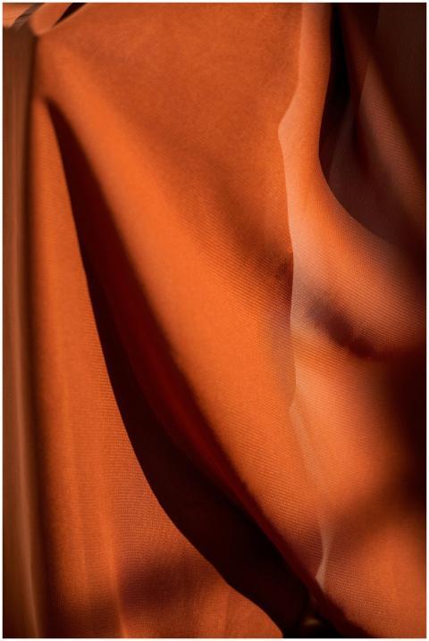A close-up of a brown cloth illuminated by sunligh