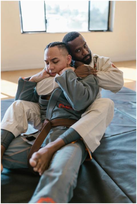 Two adult men engaged in jiu-jitsu training on ind