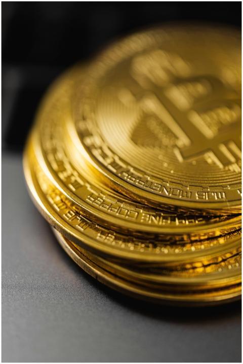 Close-up of a stack of shiny gold bitcoins on a co