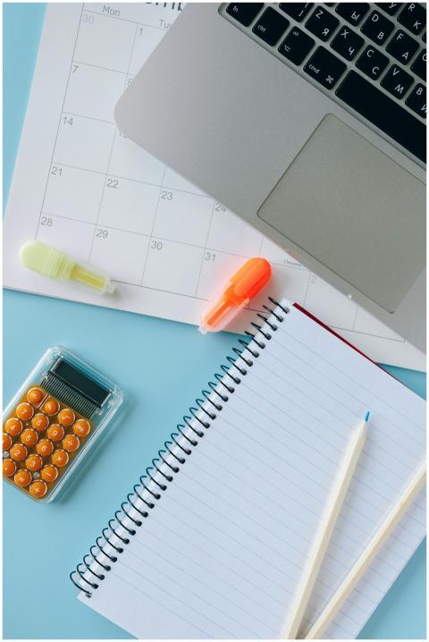 Flat lay of a workspace with a laptop, notebook, c