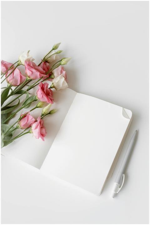 Open notebook with pink and white flowers and a pe