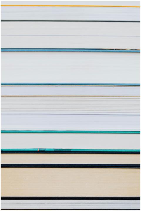 A close-up of a neatly stacked pile of hardcover b