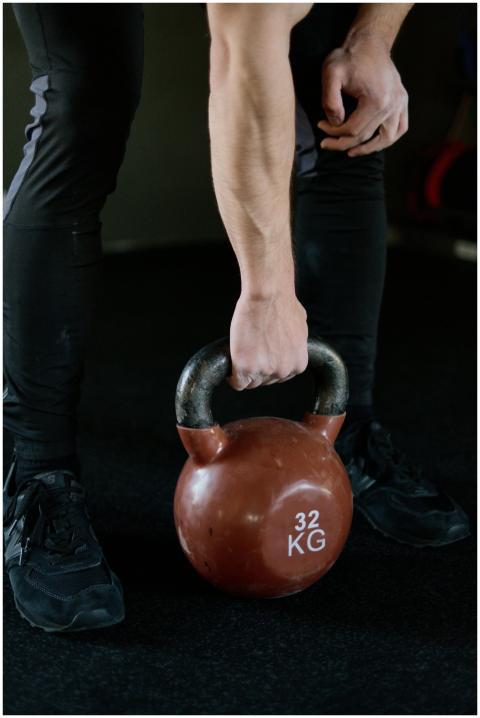 Close-up of a man's hand lifting a 32 kg kettlebel
