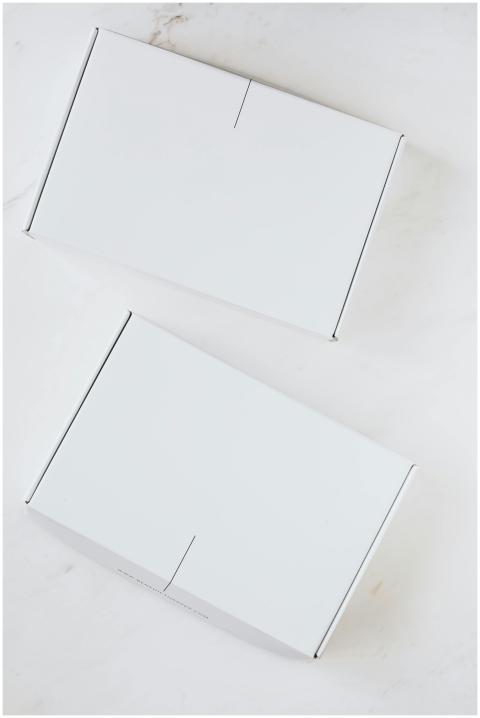 Two simple white boxes on a clean marble backgroun