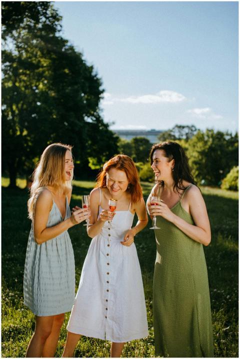 Three women enjoying champagne outdoors on a sunny