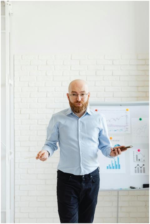 A bald man with eyeglasses presenting data on char