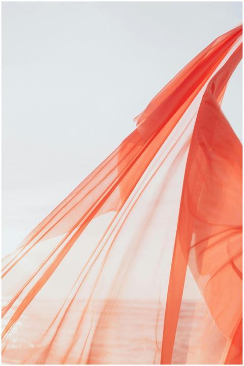 Transparent sheer fabric gracefully waves against