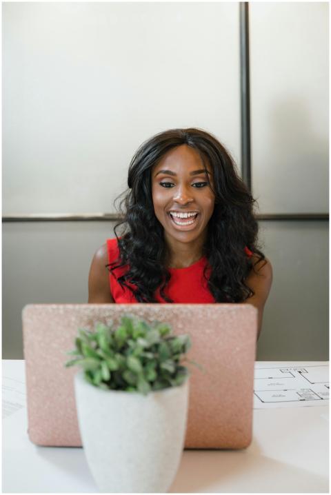 Professional woman in office, wearing red, laughin