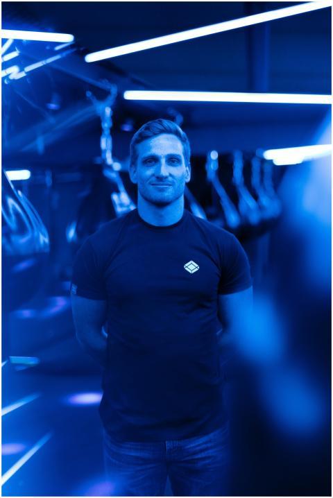 Portrait of a male gym trainer under vibrant blue
