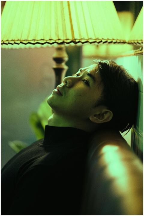 Side view of thoughtful Asian man sitting on leath