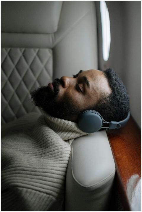 A relaxed man with wireless headphones sleeping on