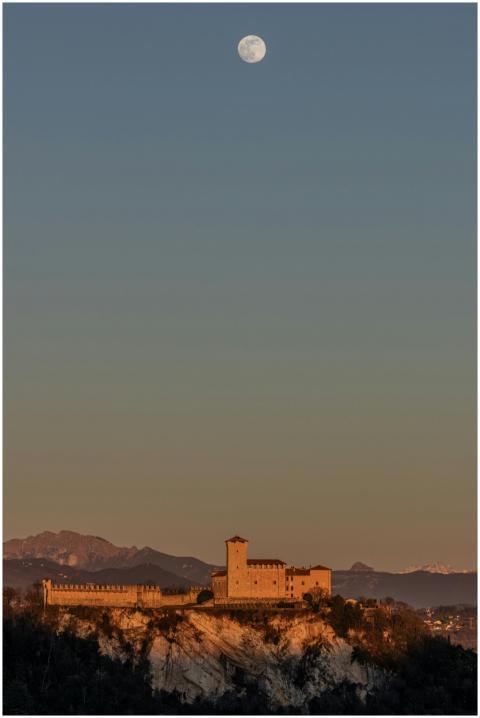 A majestic castle on a hilltop under a full moon a