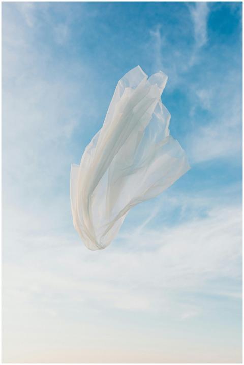 A translucent white fabric floats gracefully throu