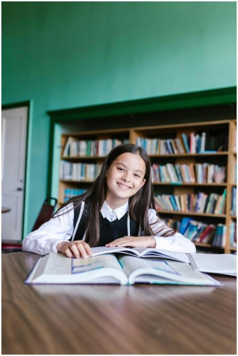 Young girl happily studying in a library, emphasiz