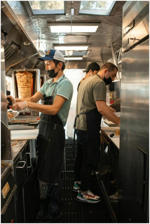 Chefs working in a food truck preparing delicious