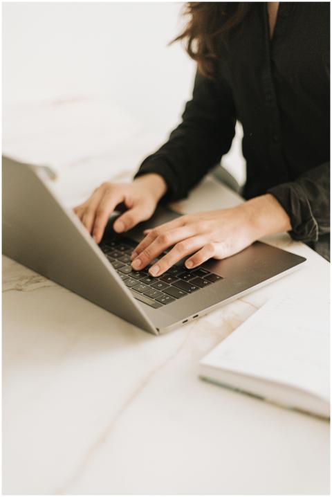 Woman typing on laptop in bright, modern workspace