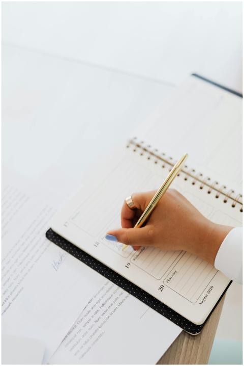 Elegant hand writing plans in a notebook with a pe