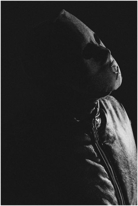 A mysterious masked person in a shadowy black and
