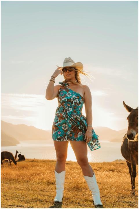 Woman in a floral dress and cowboy hat standing in