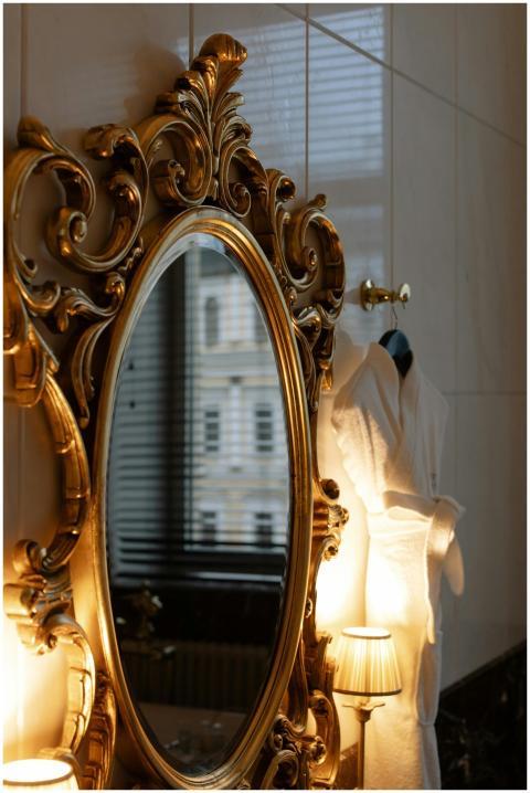 Luxurious gold framed mirror reflects a cozy inter