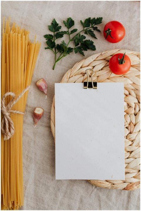 From above of blank paper with clip on wicker tabl