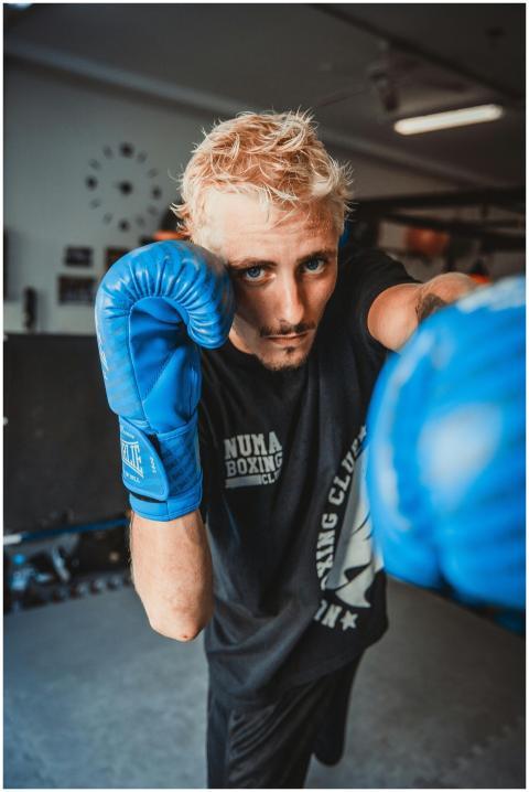 Energetic close-up of a male boxer mid-punch in an