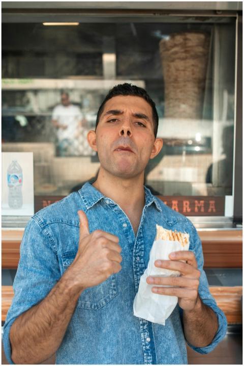 Man giving thumbs up while eating shawarma, expres