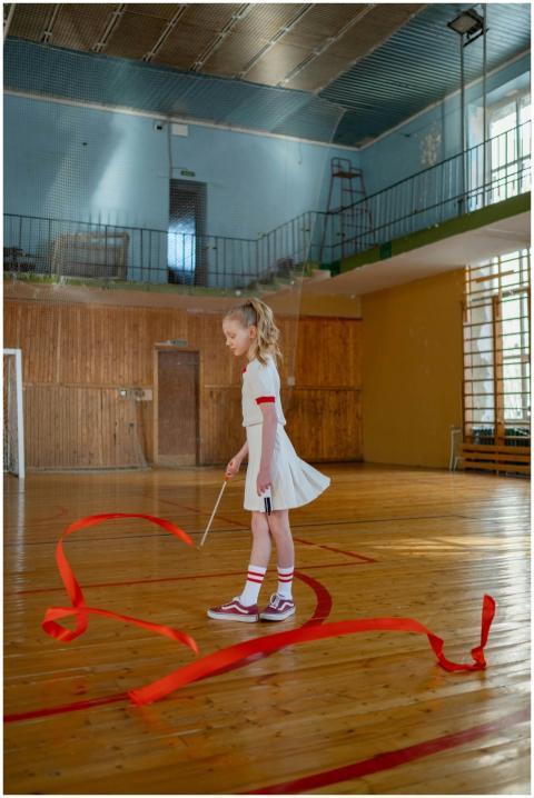 A young girl practicing rhythmic gymnastics with a