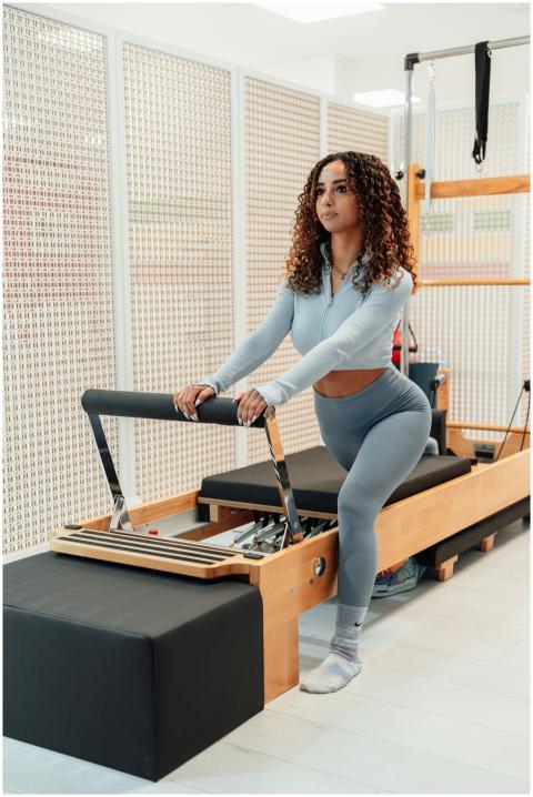 Woman exercising on pilates reformer machine indoo