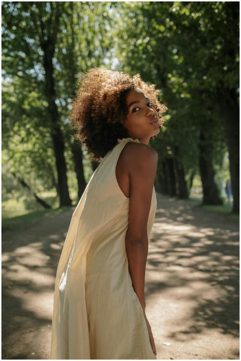 A cheerful black teenage girl poses playfully outd