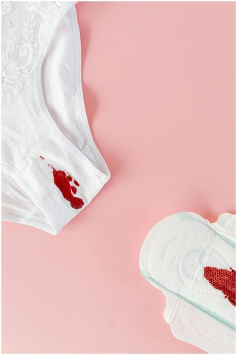 White panties and menstrual pad with blood on a pi