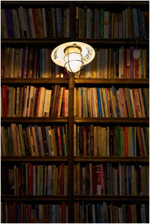 Bookshelf in a library illuminated by a warm light