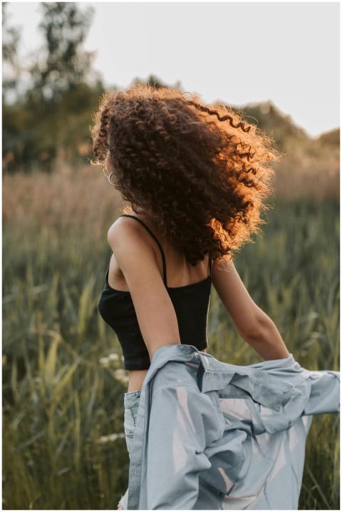 A woman with curly hair and a stylish outfit enjoy