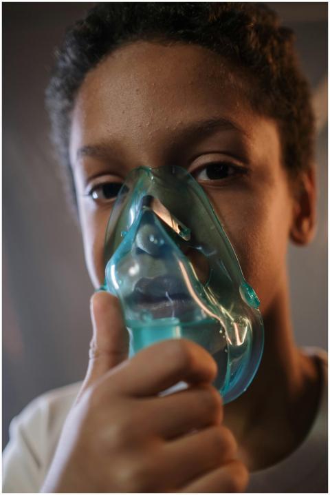 A child using an inhaler for medical treatment, em