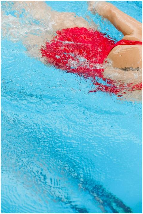Close-up of a swimmer in a red swimsuit making pow