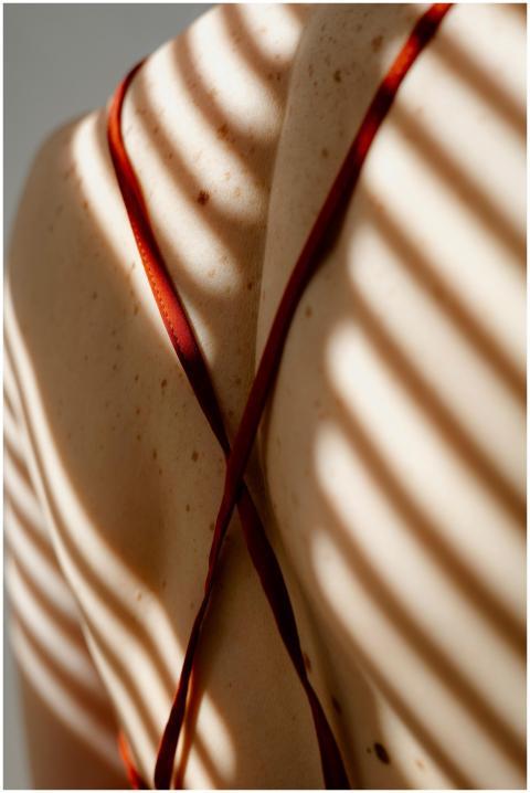 Artistic close-up of a woman's back with sunlit sh