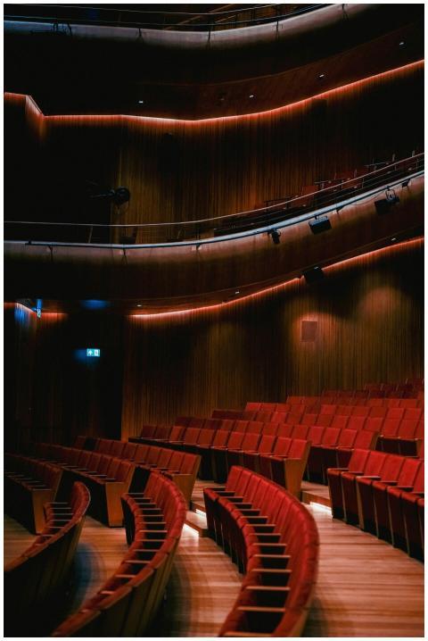 A beautifully lit theater with curved rows of red