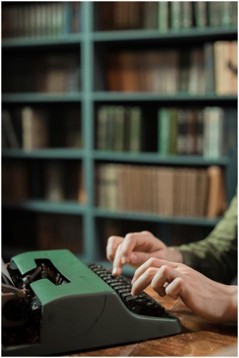 Close-up of hands typing on a vintage green typewr