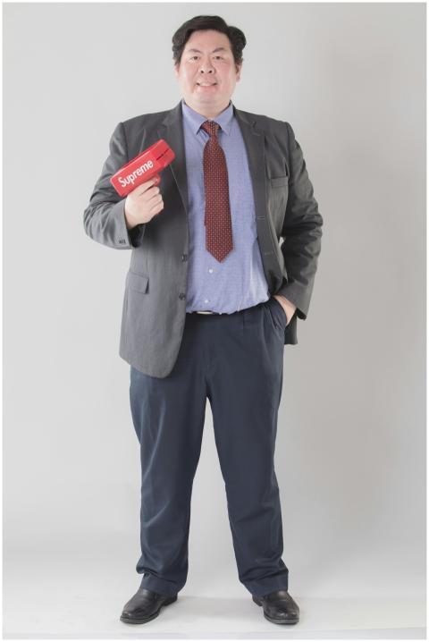 Confident businessman in a suit holding a red mone