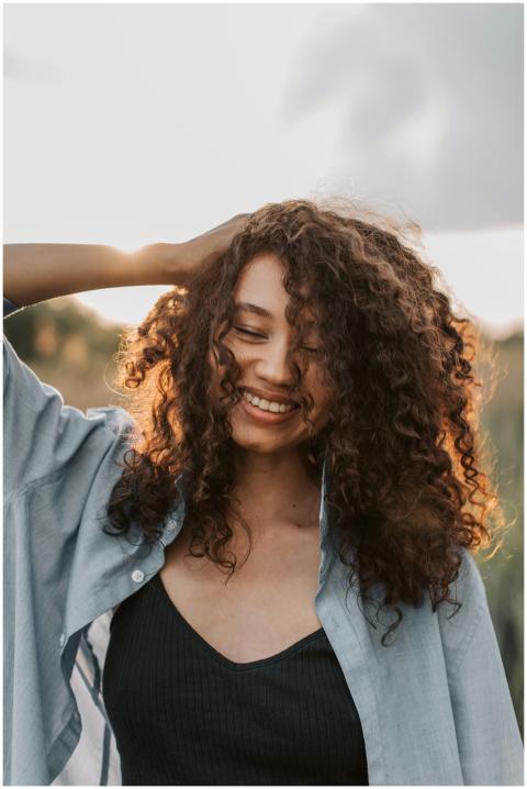 A cheerful woman with curly hair enjoys a carefree