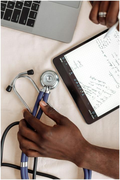 A close look at hands holding a stethoscope next t