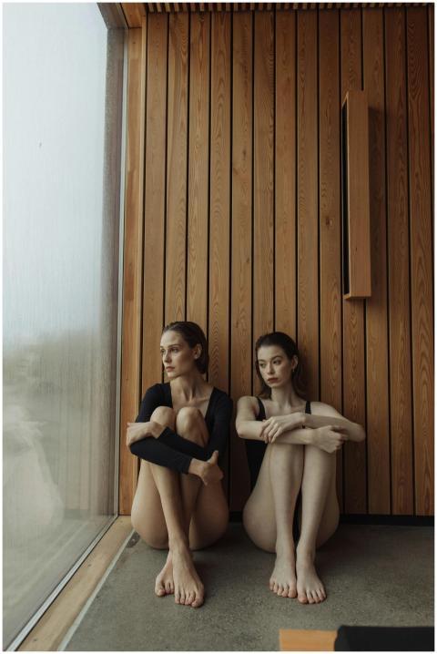 Two women sitting in a modern, wooden interior by